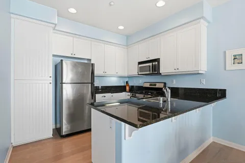 a kitchen with a refrigerator a microwave a sink and cabinets