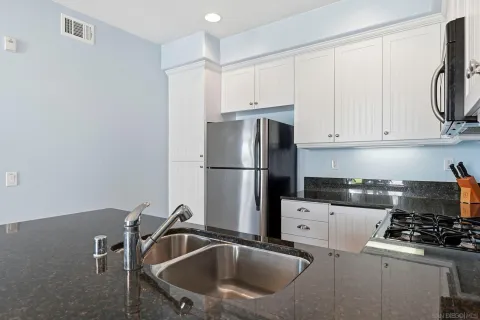 a kitchen with a sink a refrigerator and cabinets