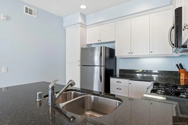 a kitchen with a sink a refrigerator and cabinets