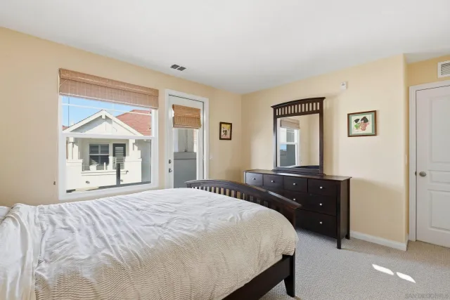 a bedroom with a bed and a dresser next to a window