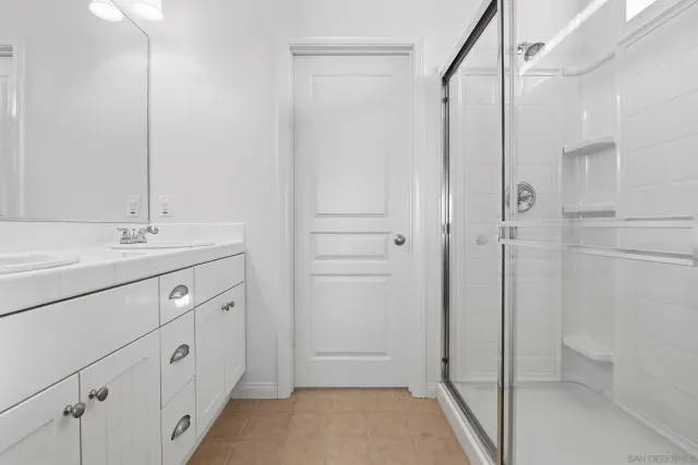 a spacious bathroom with a shower sink and mirror