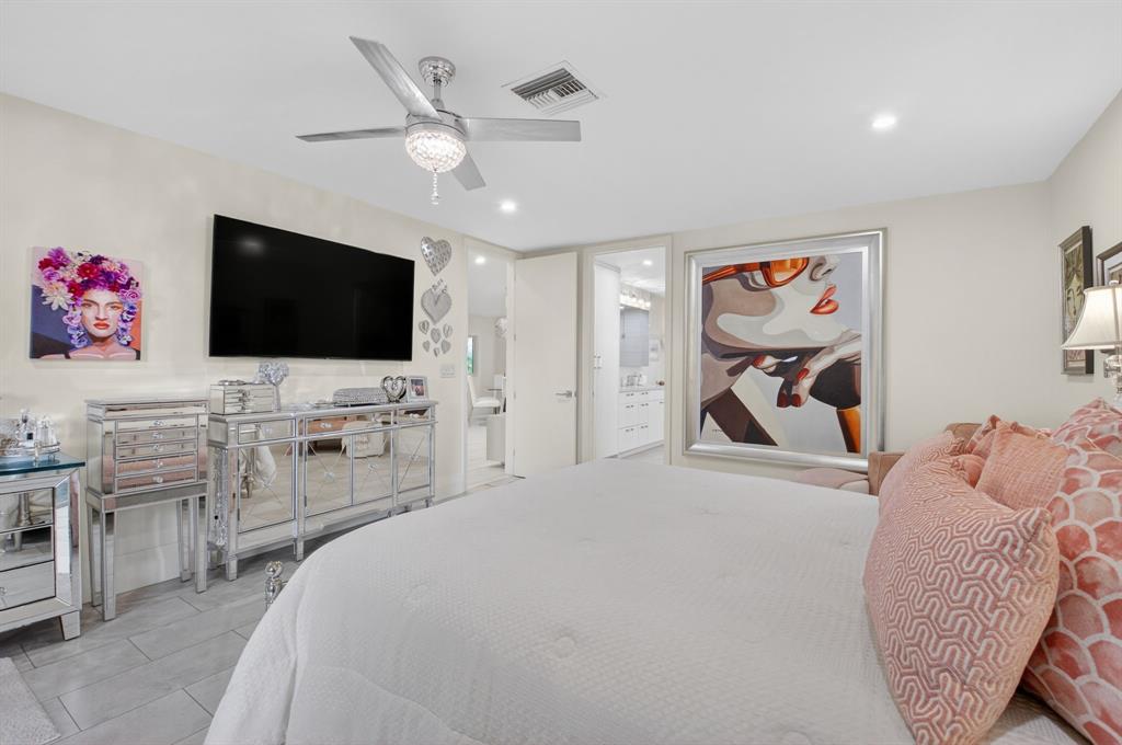 19452 Waters Reach Lane, Unit 305 Boca Raton, FL 33434 - Photo 19 of 77 a bedroom with furniture and a flat screen tv