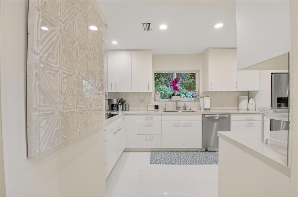 19452 Waters Reach Lane, Unit 305 Boca Raton, FL 33434 - Photo 3 of 77 a large white kitchen with cabinets