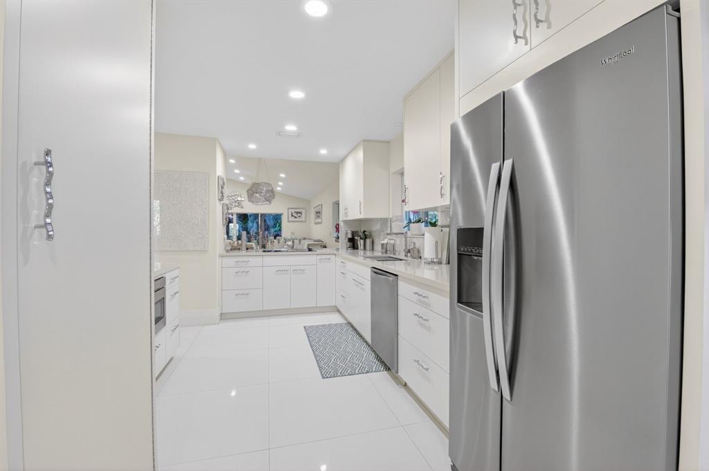 19452 Waters Reach Lane, Unit 305 Boca Raton, FL 33434 - Photo 6 of 77 a kitchen with white cabinets and refrigerator