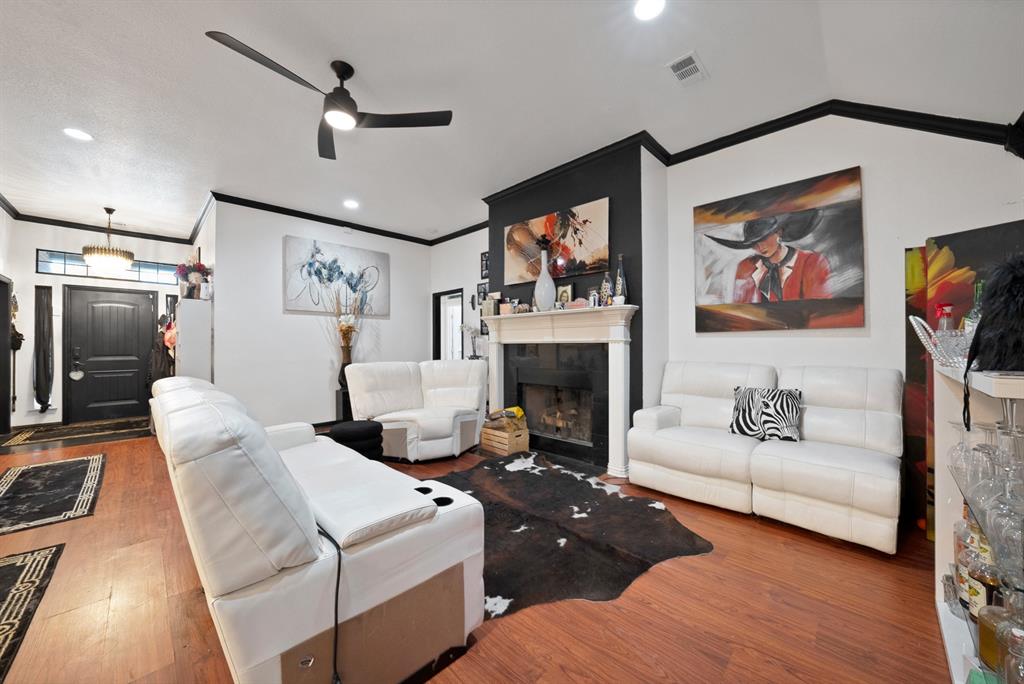 2716 Rochelle Point Irving, TX 75062 - Photo 10 of 40 Warm wood-finish flooring with a white wood mantel fireplace and black surround