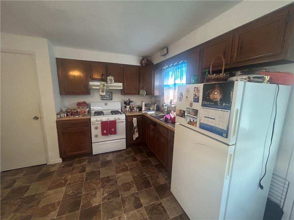100 Quarry Street Rochester, PA 15074 - Photo 5 of 16 a kitchen with stainless steel appliances granite countertop a refrigerator a stove a sink and a microwave