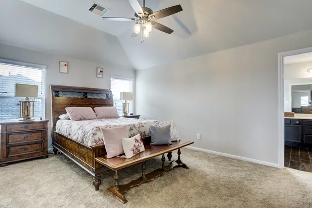 a bed sitting in a bedroom and chandelier