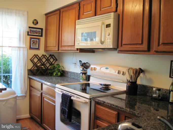 7439 Ridge Oak Court Springfield, VA 22153 - Photo 1 of 10 a kitchen with stainless steel appliances granite countertop a sink and cabinets