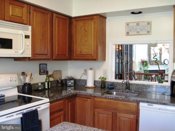 7439 Ridge Oak Court Springfield, VA 22153 - Photo 6 of 10 a kitchen with granite countertop a sink stove and cabinets