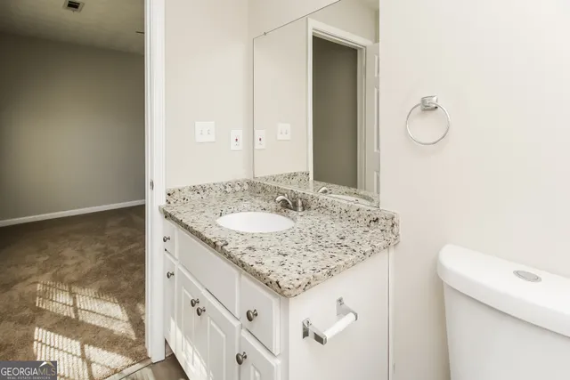 a bathroom with a granite countertop sink and a mirror