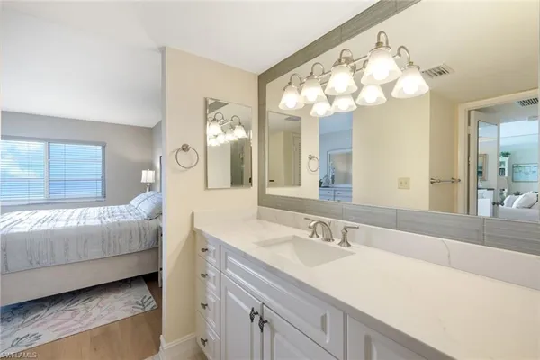 a en suite bathroom with a double vanity sink and a mirror