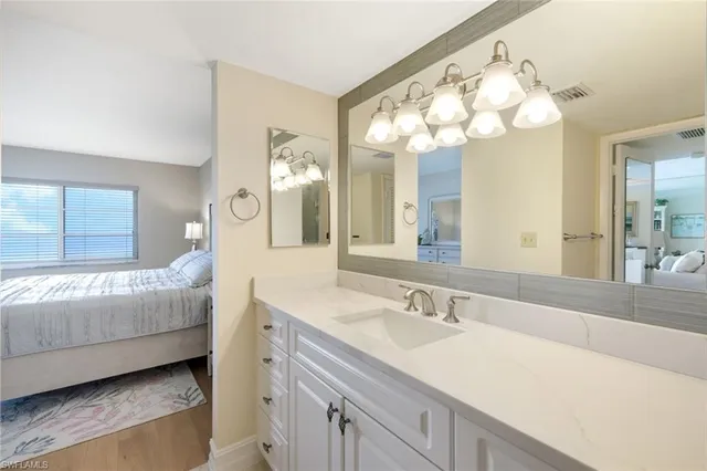 a en suite bathroom with a double vanity sink and a mirror