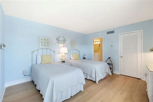 a bedroom with two beds and painting on the wall