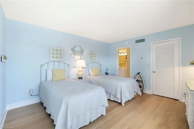 a bedroom with two beds and painting on the wall