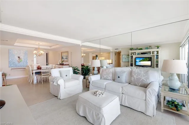 a living room with furniture a table and a potted plant