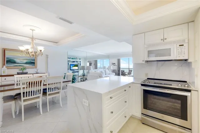 a kitchen with stainless steel appliances a stove a sink a dining table and chairs