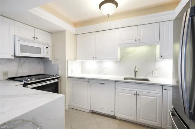 a kitchen with white cabinets and white appliances