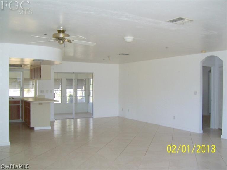 113 Georgia Road Lehigh Acres, FL 33936 - Photo 3 of 9 wooden floor in an empty room with a window