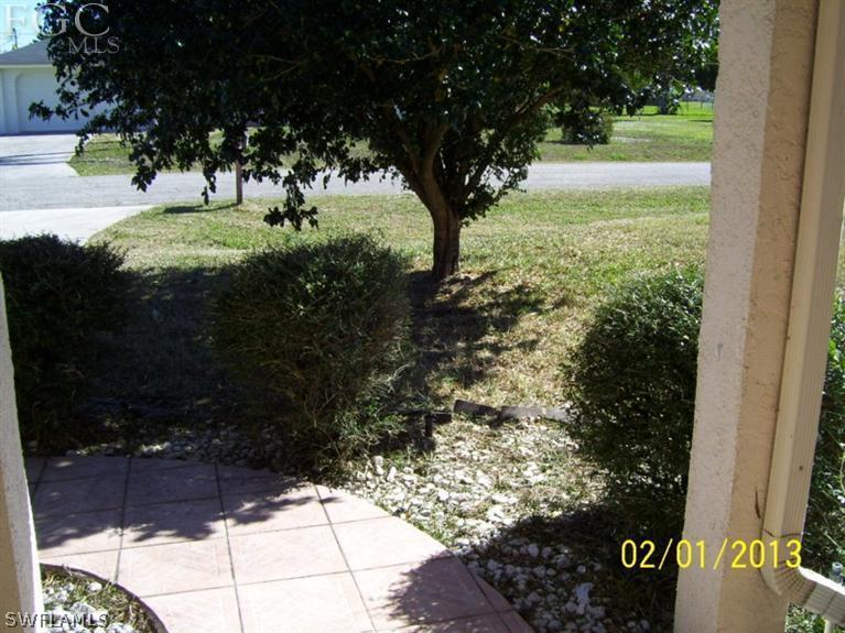 113 Georgia Road Lehigh Acres, FL 33936 - Photo 8 of 9 a view of a yard with yellow tree