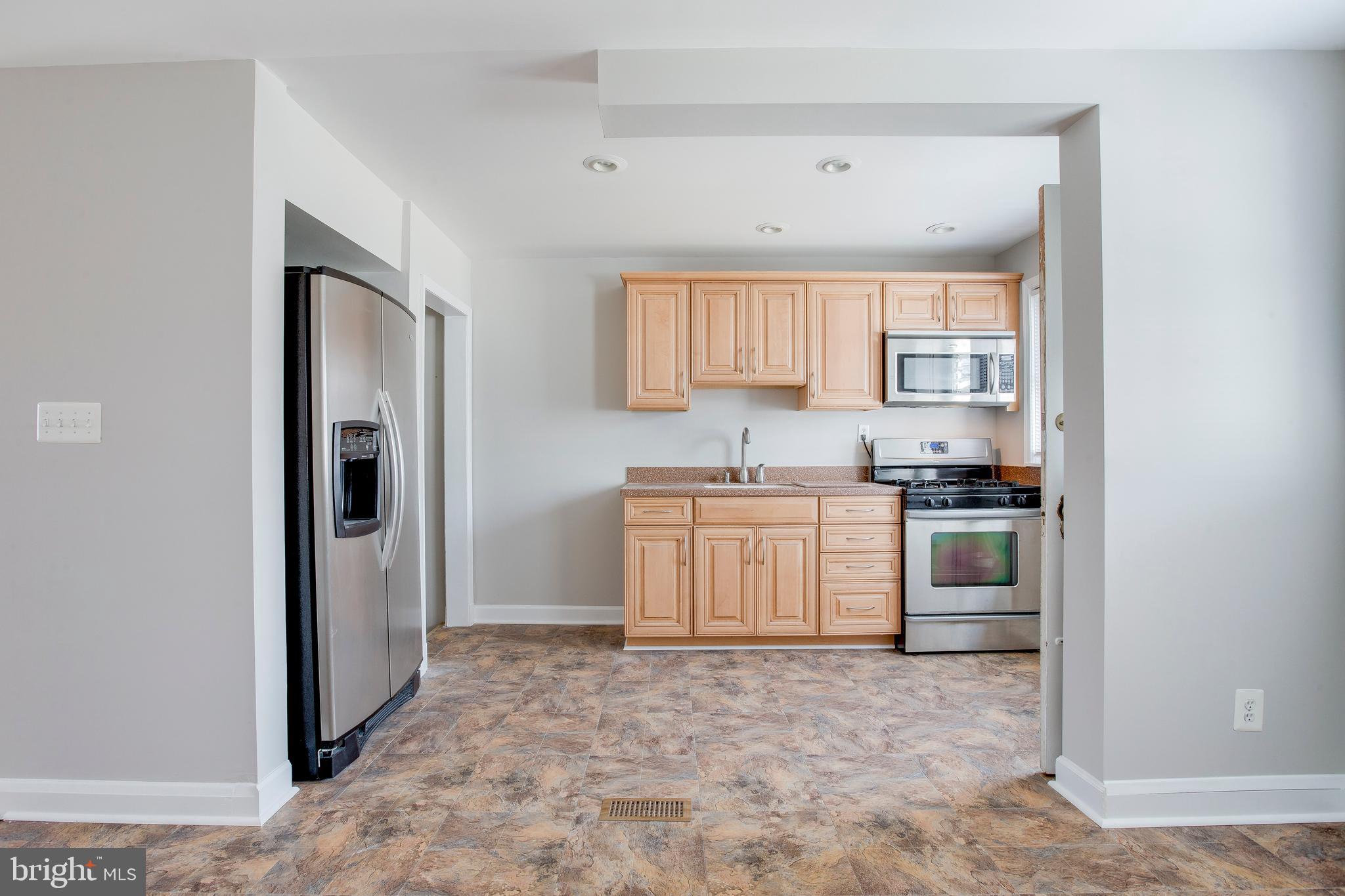 2255 Searles Road Baltimore, MD 21222 - Photo 4 of 13 a kitchen with a refrigerator sink and cabinets