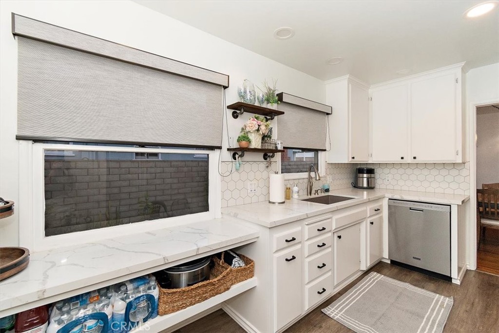 8530 Harmony Lane Riverside, CA 92504 - Photo 12 of 40 a kitchen with stainless steel appliances white cabinets and wooden floor