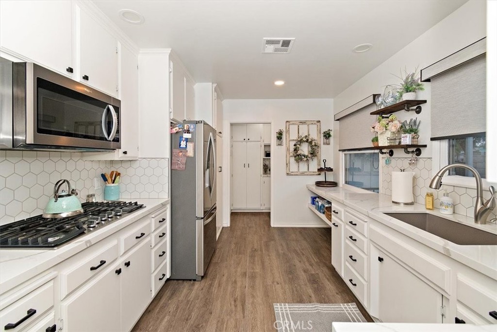 8530 Harmony Lane Riverside, CA 92504 - Photo 7 of 40 a kitchen with stainless steel appliances kitchen island granite countertop a sink stove and refrigerator