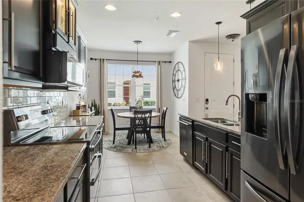 a kitchen with stainless steel appliances granite countertop a sink stove and refrigerator