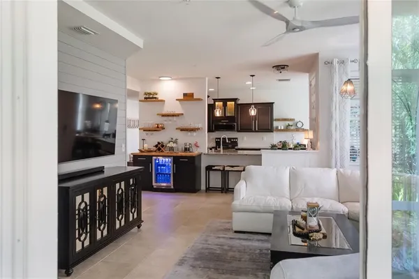 a living room with stainless steel appliances furniture and a kitchen view