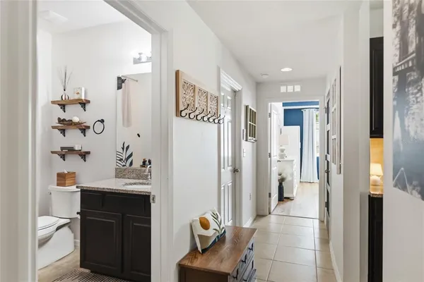 a view of a hallway with bathroom and mirror