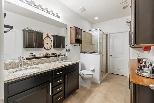 a bath room with a toilet a sink and a mirror