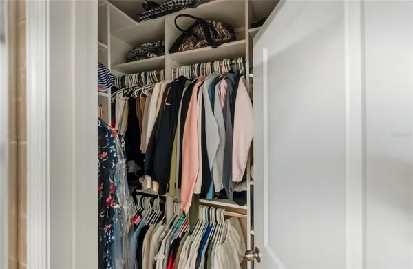 a view of walk in closet with clothes
