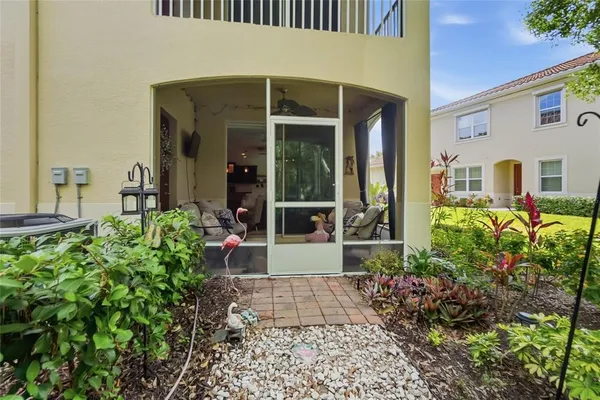 a view of a house with potted plants and a table and chairs