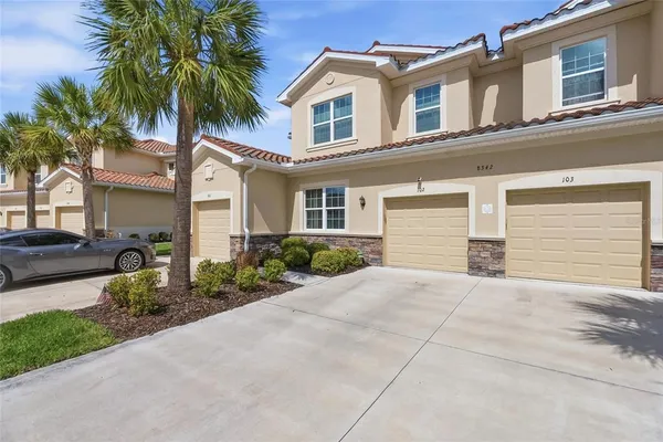 a view of a house with a yard and palm trees