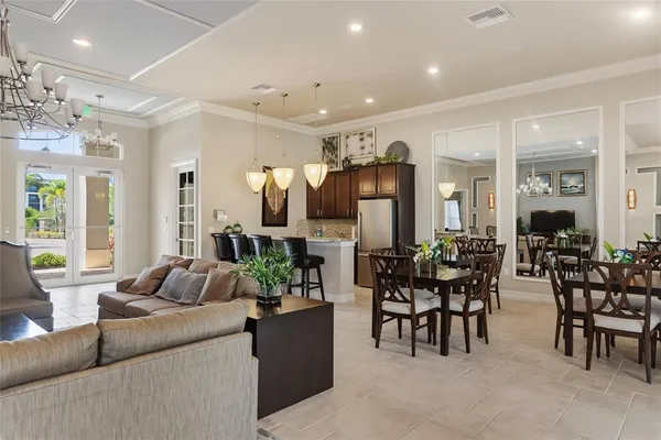 a living room with furniture a large window and a dining table
