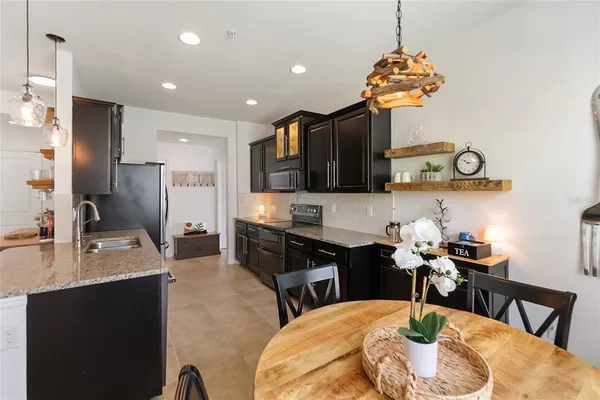 a kitchen with a dining table chairs sink and granite counter tops