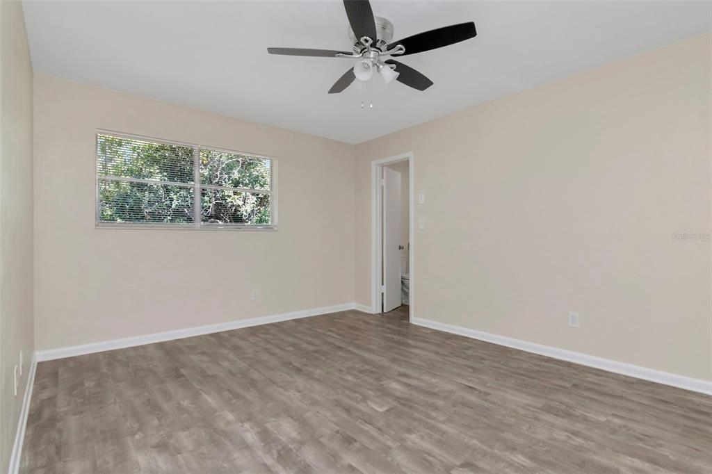 126 Kingsway Road Brandon, FL 33510 - Photo 29 of 42 an empty room with wooden floor fan and windows