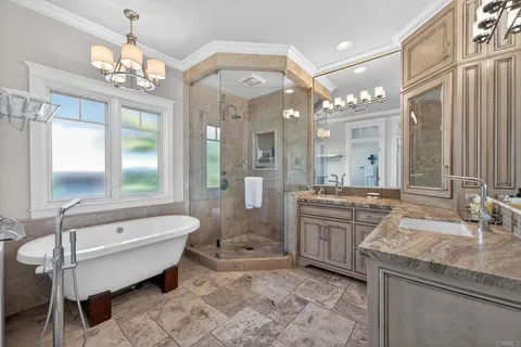 a bathroom with a granite countertop double vanity sink a mirror and a shower