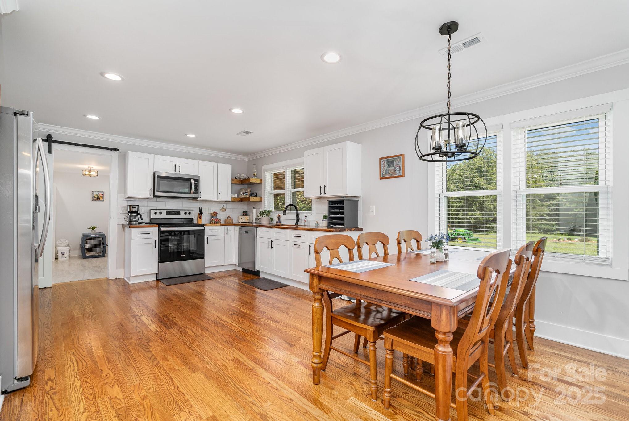 2295 Emanuel Church Road Rockwell, NC 28138 - Photo 12 of 33 a dining room filled chandelier and wooden floor