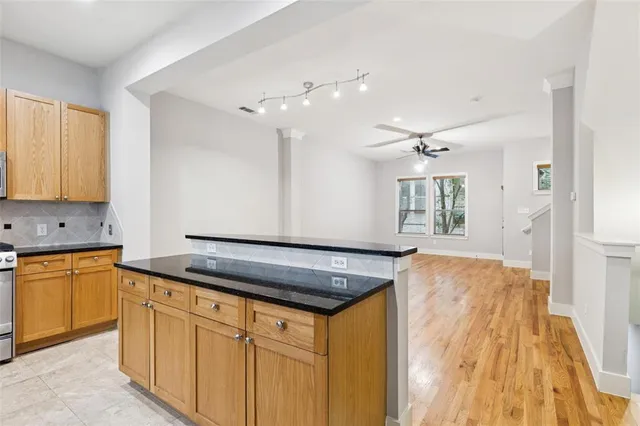 a kitchen with granite countertop a sink cabinets and wooden floor