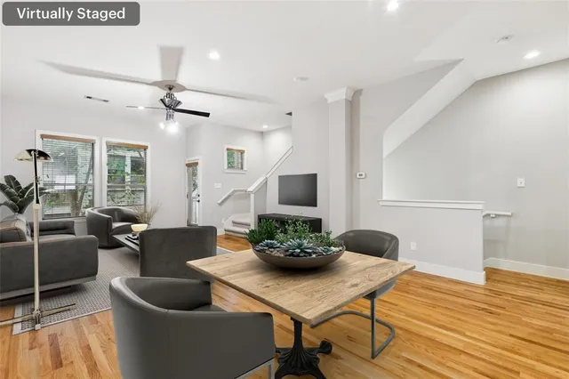 a living room with furniture potted plant wooden floor and a large window