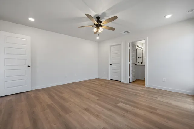 wooden floor in an empty room with a ceiling fan