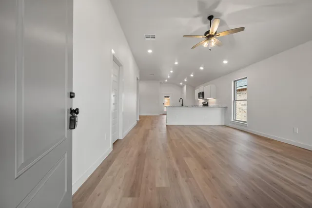 a view of a hallway with wooden floor and chandelier