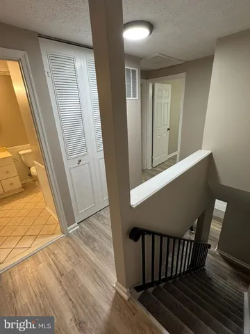 a view of a hallway with wooden floor and staircase