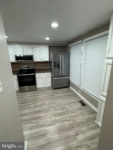 a large kitchen with a stove and a refrigerator