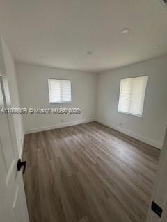 2201 Northwest 6th Court, Unit 2201 Fort Lauderdale, FL 33311 - Photo 5 of 8 an empty room with wooden floor and windows