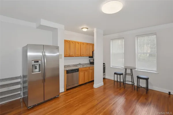 a kitchen with granite countertop a refrigerator and wooden floor