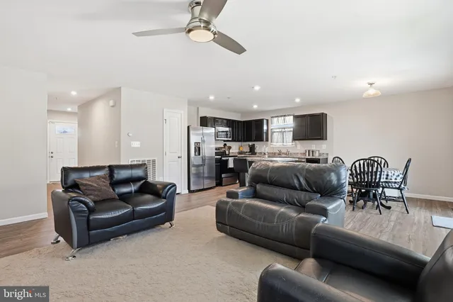 a living room with furniture kitchen view and a chandelier