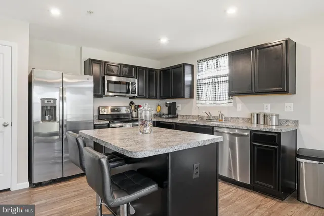 a kitchen with granite countertop a sink stove and refrigerator