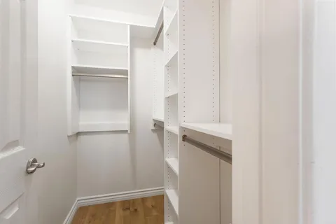 a view of walk in closet with empty racks