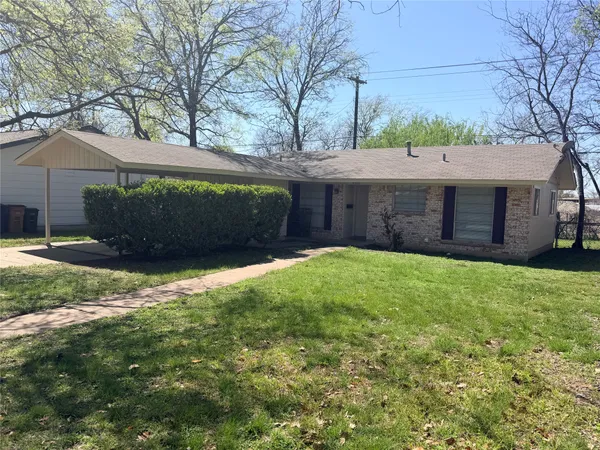 a view of a house with a yard and a large tree
